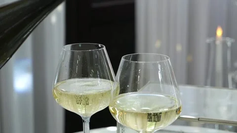 Close-up of a man pouring champagne into two glasses in a restaurant. Stock Footage 333246202
