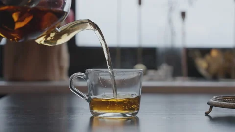 Close-up of a man pouring hot tea into a cup Stock Footage 294253924