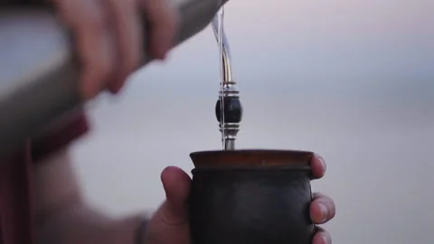 Close-up of man pouring water preparing typical Argentine hot drink. Yerba Mate. Stock Footage 296582115