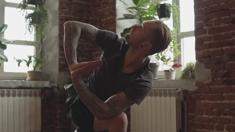 Close-up of Man practice yoga pose in studio with brick wall in slow motion Vídeo Stock 107103458