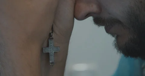 Close up of a man praying. Holding a cross in his hands Видео 121504688