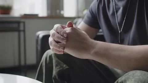 Close-up of man praying or meditating with hands clasped Stock Photos