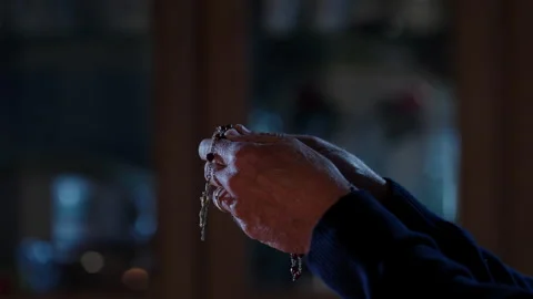 Close-up Man praying with Rosary in dining room  Stock Footage 291574999