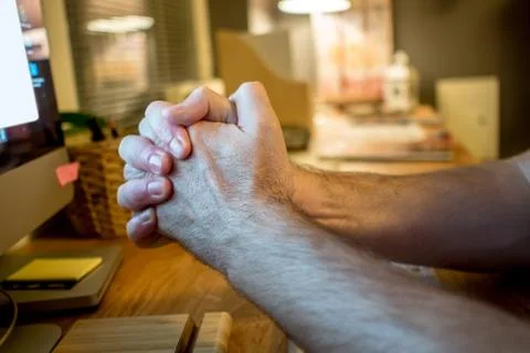 Close-up of a man praying with the typical hands gesture in front of the scre Stock Photos