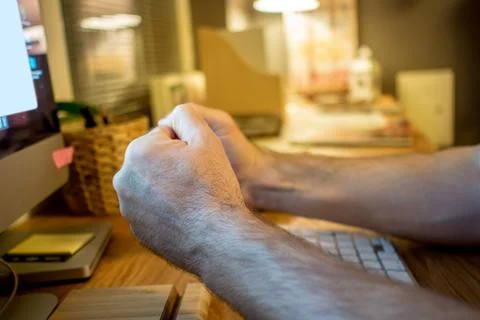 Close-up of a man praying with the typical hands gesture in front of the scre Stock Photos