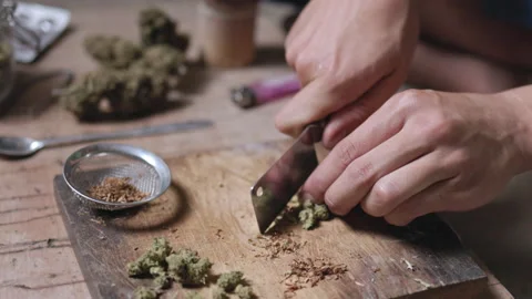 Close-up of a man preparing cannabis medicine for consumption. Man smokes c.. Stock Footage 336969476