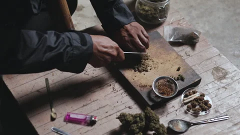 Close-up of a man preparing cannabis medicine for consumption. Man smokes c.. Stock Footage 336970543