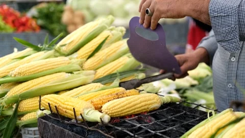 Close-up of a man preparing corn on the grill Stock Footage 268685411