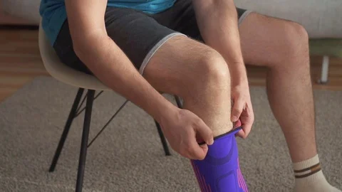 Close up of a man preparing for training, with a bandage on his knee slow mo Stock Footage 106491042