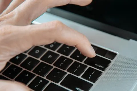 Close up. man pressing the Delete key on his laptop. Stock Photos