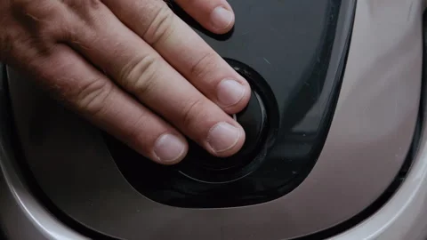 Close-up of man pressing vacuum cleaner power button Video stock 317973573