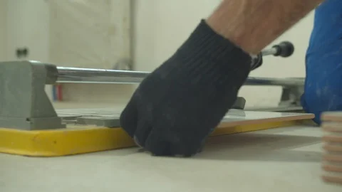 Close up, man in protective gloves cuts a tile Stock Footage 124843454