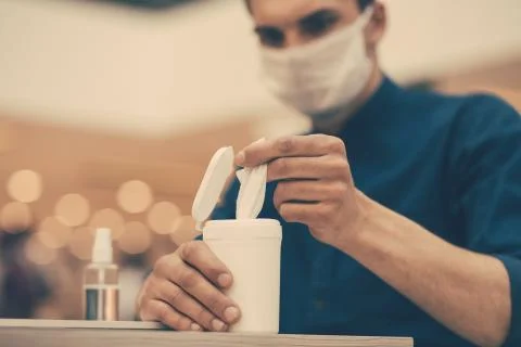 Close up. a man in a protective mask using antiseptic wipes Stock Photos