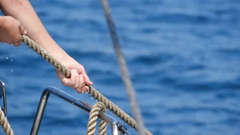 Close up of man pulling sail ropes during sailing trip on mediterranean sea. Stock Footage 114699787