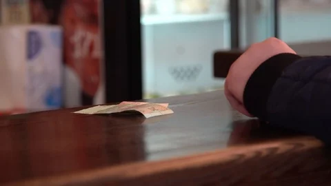 A close-up of a man puts a bill on a bar counter. cafe, customers pay for food Vídeos de archivo 123044238