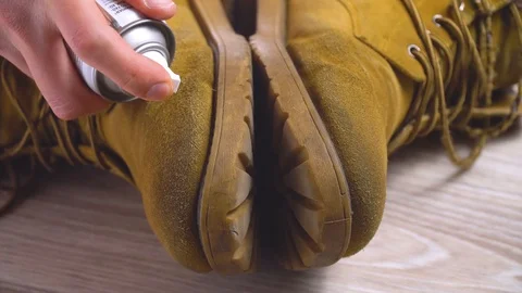 Close-up man puts cleaning foam on dirty shoes from nubuk Stock Footage 128627215