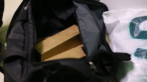 Close-up. The man puts the gold bars in a sports bag. Plastic bag 스톡 동영상 128195732