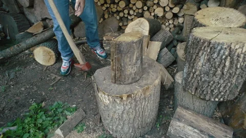 Close-up of a man puts a log on a stump and chops it with an ax Stock-Footage 253573885