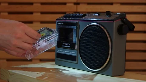 Close-up on a man putting compact cassette into recorder with studio light Video stock 77409432