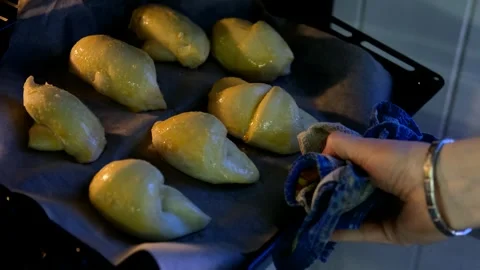Close-up of a man putting croissant blanks into the oven for cooking Video stock 294833459
