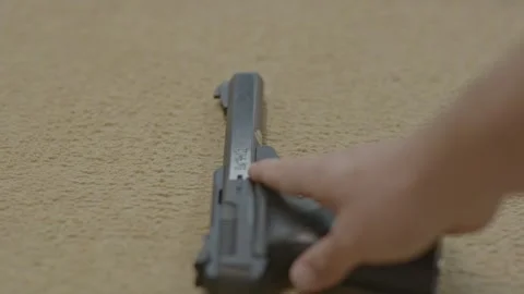 Close up of man putting down loaded handgun Video stock 249300108