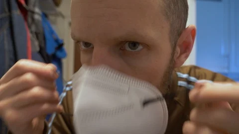 Close up of man putting on face mask on for prevention of Covid-19 Coronavirus Stock Footage 129498819