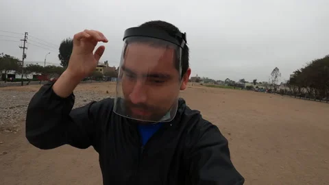 Close up of a man putting on his mask, face shield and romper while running Vidéo 141656620