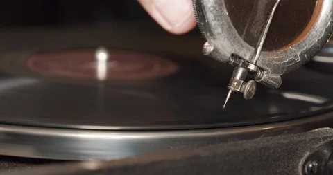 Close-up of a man putting a needle in a vinyl record on a vintage gramophone. Stock Footage 98614264