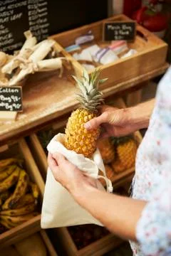 Close Up Of Man Putting Pineapple Into Reusable Cotton Bag In Plastic Free Stock Photos