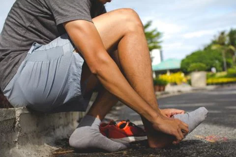 Close-up of man putting on sock before workout. Stock Photos