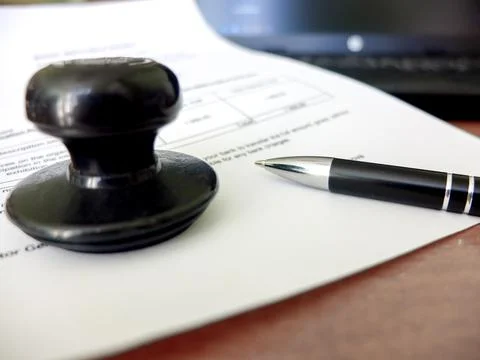 Close-up of a man putting a stamp on a document. Business concept Stock Photos