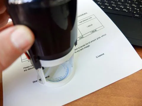 Close-up of a man putting a stamp on a document. Business concept Stock Photos