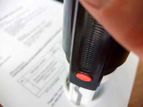 Close-up of a man putting a stamp on a document. Business concept Stock Photos