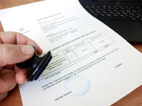 Close-up of a man putting a stamp on a document. Business concept Stock Photos