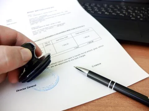 Close-up of a man putting a stamp on a document. Business concept Stock Photos