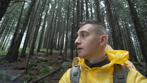 Close-up of a man in a raincoat in the forest during the rain. Stock Footage 214330647