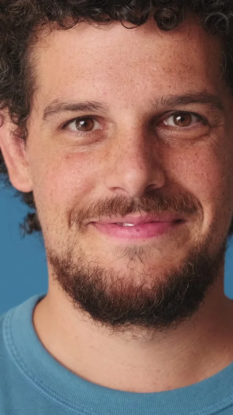Close-up, man raising his head and looking at the camera with smile isolated on Video stock 252502030