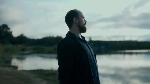 Close-up of man reacting emotionally while reading a letter by the lake Stock Footage 313606069