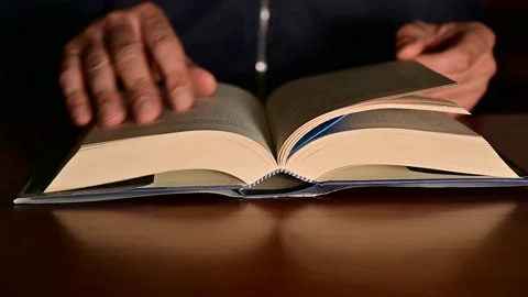 Close up of man reading checking a book on wooden desk Stock Footage 165420980