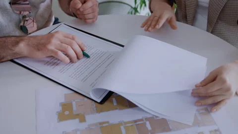 Close-up of Man Reading Mortgage Contract with Agent Assisting Stock-Footage 311820253