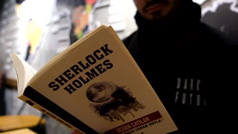 Close up of a man reading sherlock holmes book Stock Footage 167740218