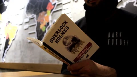 Close up of a man reading sherlock holmes book Stock Footage 167740245