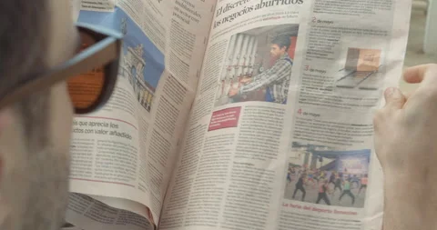 Close up: Man reads newspaper on the beach Stock Footage 205022855
