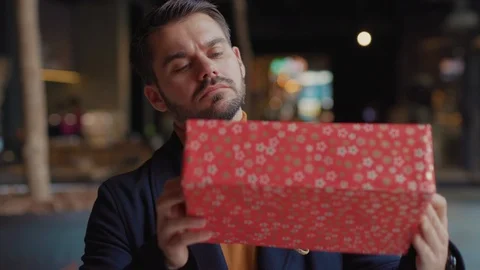 Close up man received the gift and does not know what is there look at camera Stock Footage 120267170