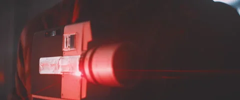 Close up of man in red lights holding vintage camera Stock Footage 203561007