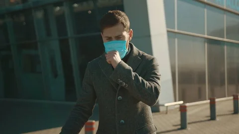 Close up man removes Protective Face Mask sneeze coughs hold suitcase COVID-19 Stock Footage 126580450
