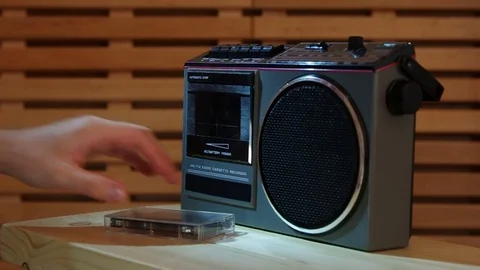 Close-up on a man removing compact cassette from recorder with studio light Video stock 77409425