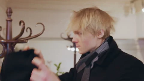Close up of man removing his black beanie to reveal blonde hair in indoor Vídeo Stock 344866210