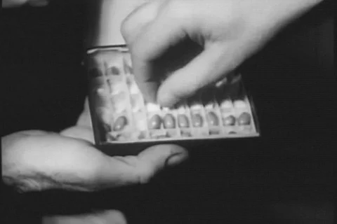 Close-up of man removing pill from box, 1950s Stock Footage 90727595