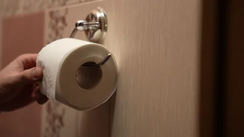 Close-up of man replacing empty toilet paper roll with new white roll Vídeos de archivo 325802251